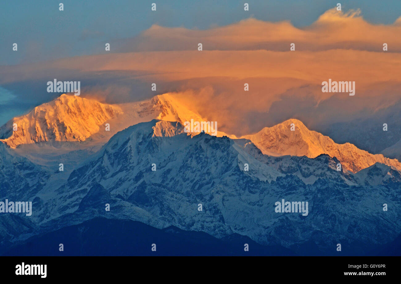 Mt.Kanchenjunga, the Third Highest mountain in the world at 8586 meters, at sunrise with hanging clouds around it, Sikkim, India Stock Photo