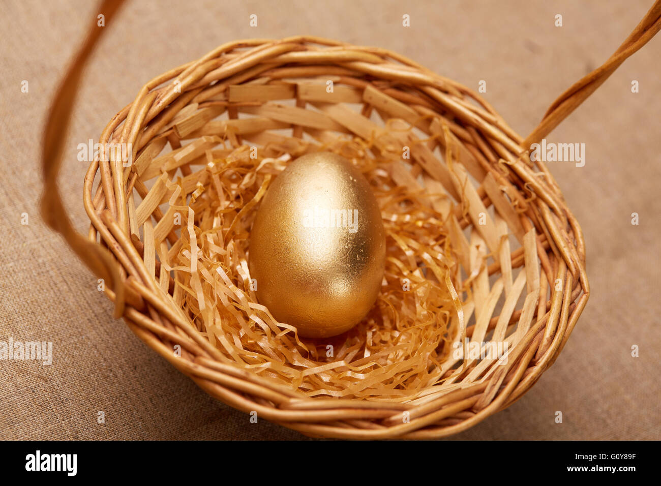 golden egg in a basket Stock Photo Alamy