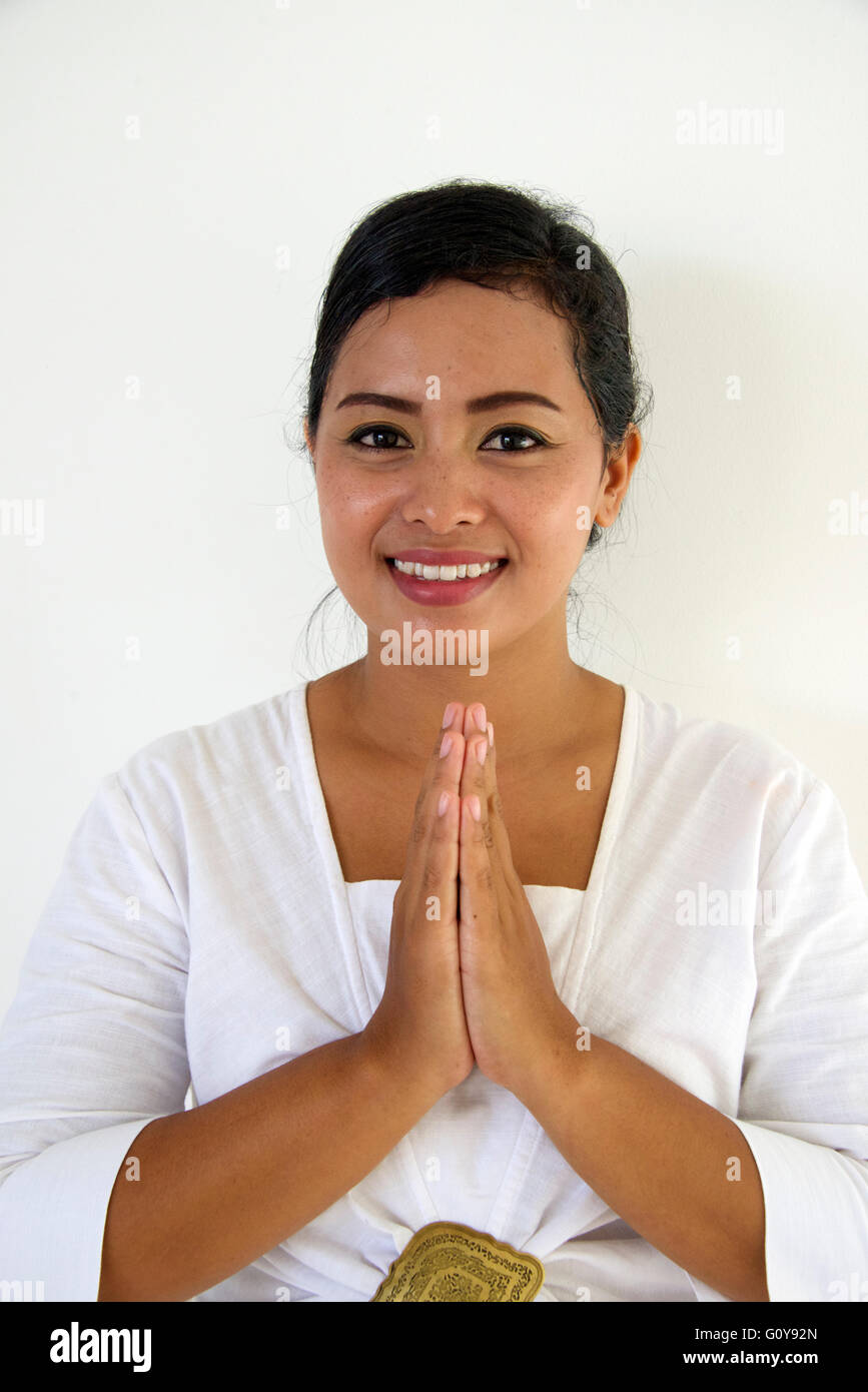 Pretty Balinese girl with welcoming clasped hands Bali Indonesia Stock Photo