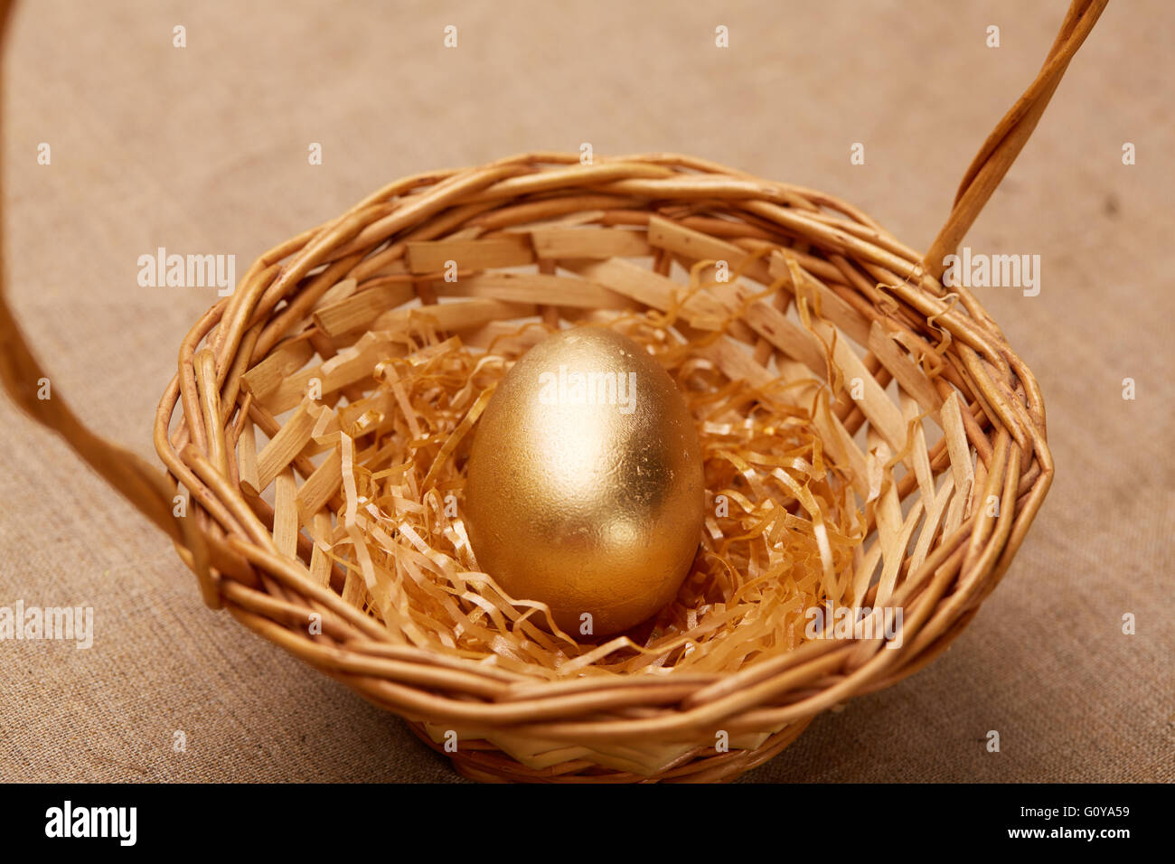 golden egg in a basket Stock Photo Alamy