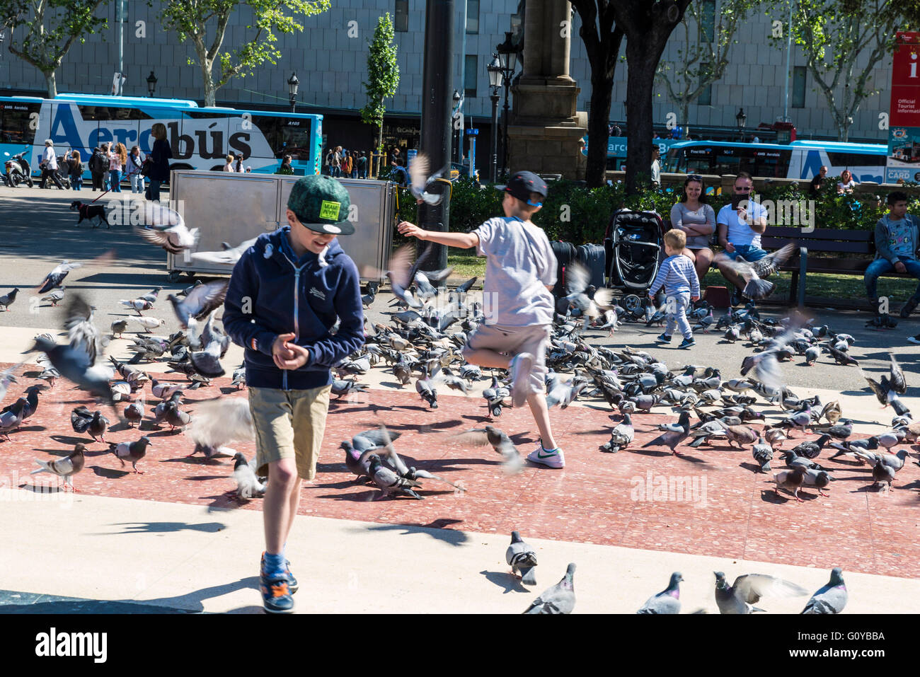 School children playing to scare away pigeons in Barcelona, Catalonia, Spain Stock Photo