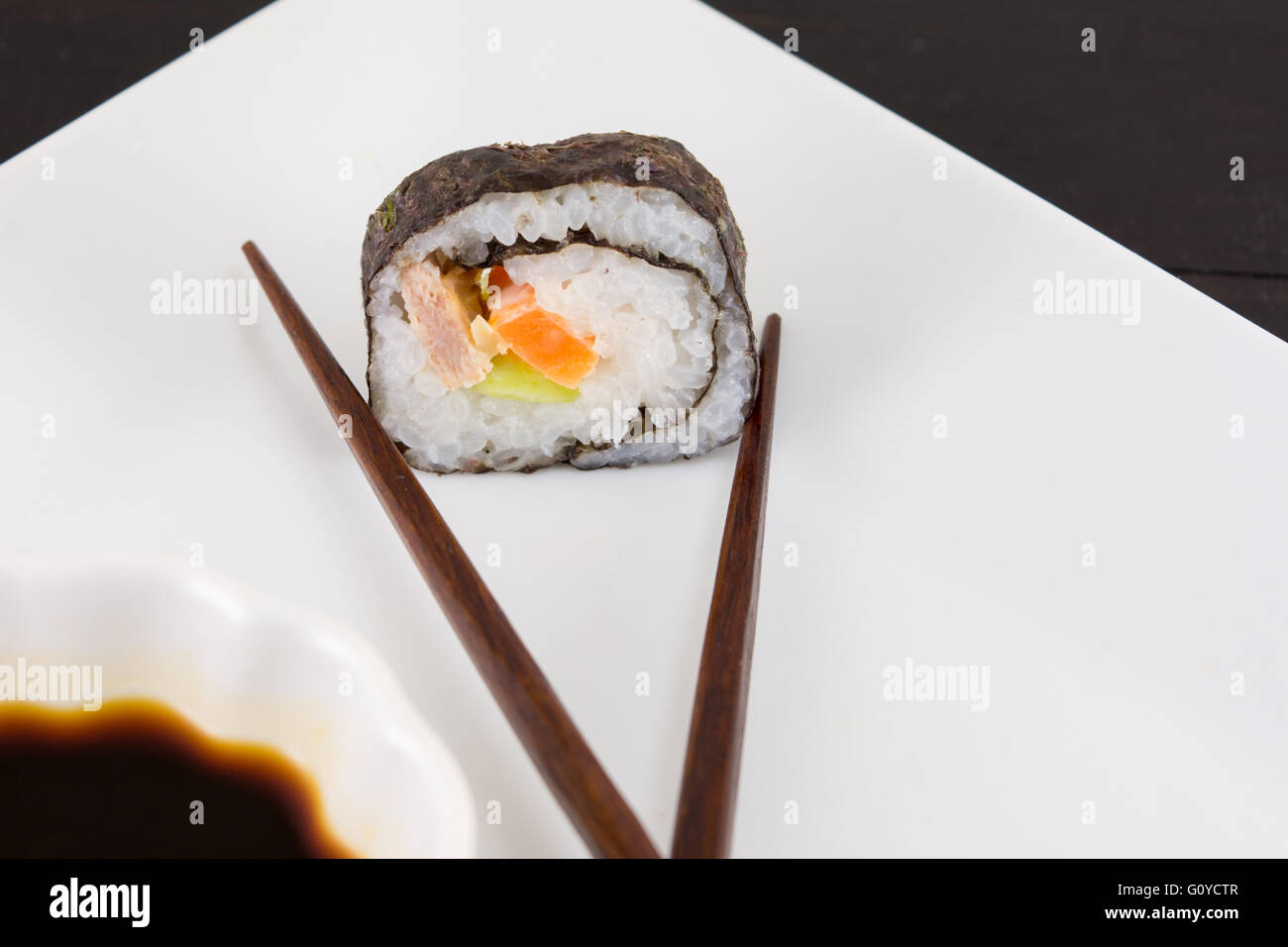 Sushi roll caught by chopsticks Stock Photo