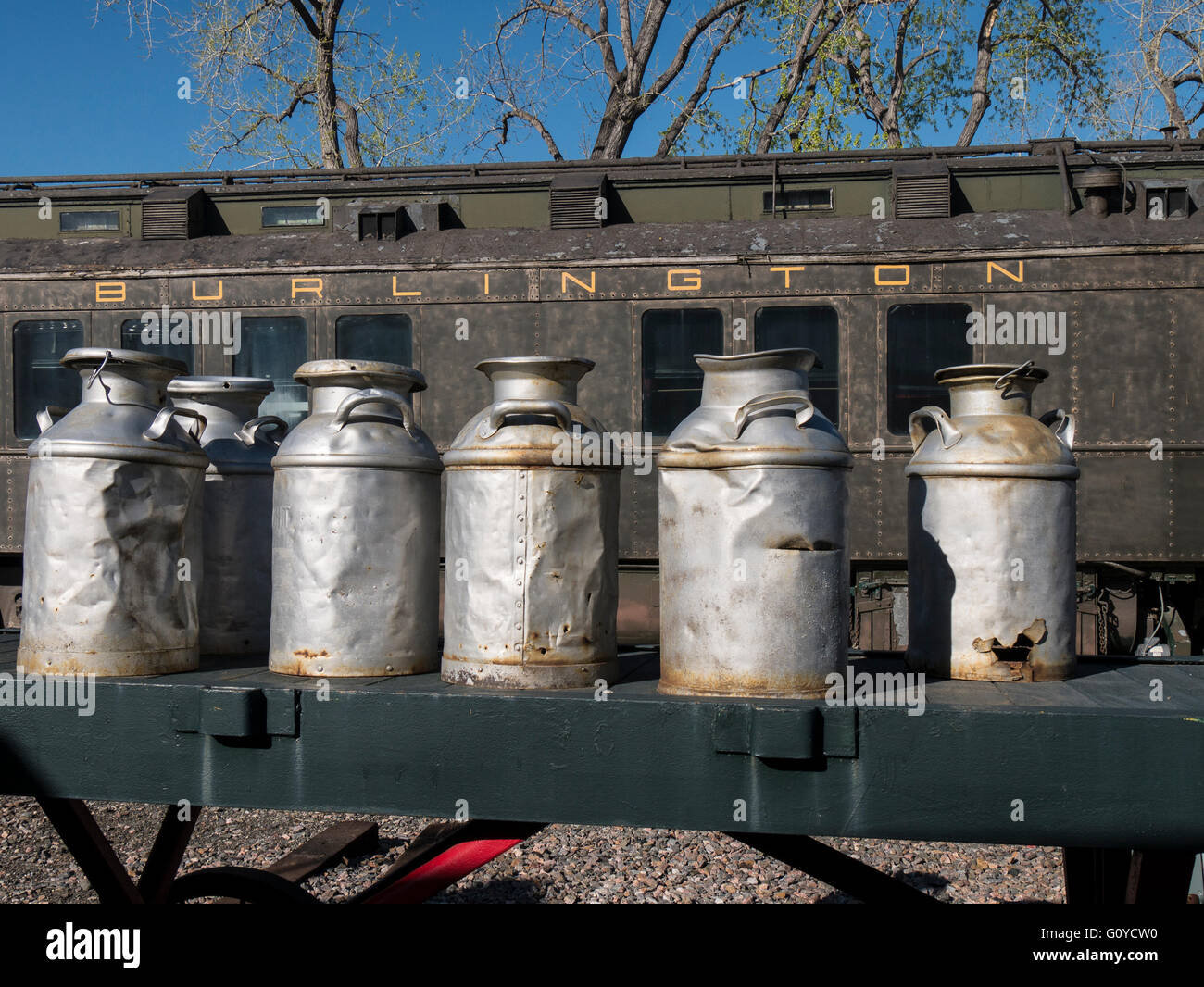 Steel milk jugs on rail cart with Chicago Burlington & Quincy Business Car #96 (S),  Colorado Railroad Museum, Golden, Colorado. Stock Photo