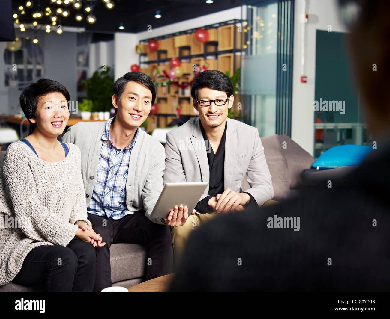 a team of young asian business people talking to boss and or investor Stock Photo