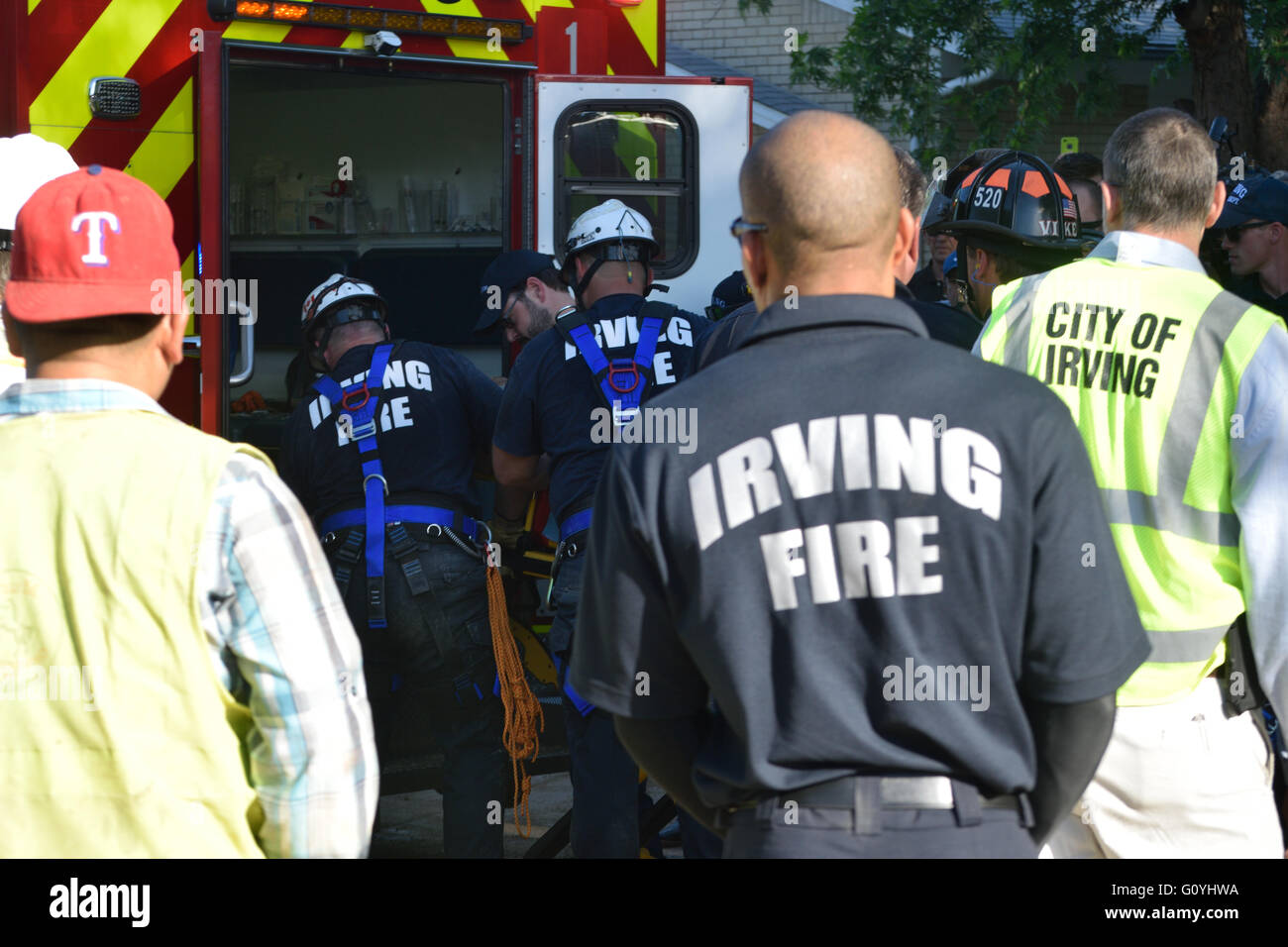 Irving, TX, USA. 5th May, 2016. Rescue workers watch as paramedics place injured  construction worker into an ambulance. Credit:  Brian Humek/Alamy Live News. Stock Photo