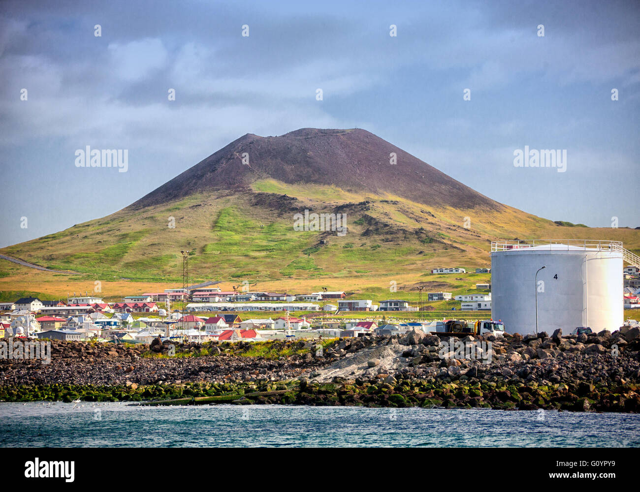 August 3, 2015 - Infamous Eldfell volcano, over 200 m (660 ft) high, overlooking Heimaey port on Heimaey Island, in the Westman Islands archipelago group (Vestmannaeyjar), scattered off the south coast of Iceland. In 1973, without warning, lava flow and volcanic ash, from its violent eruption destroyed half the town and threatened to close the harbor, its main income source. Dependent on its fishing industry, but noted for its seabird population, tourism and bird watching are a growing sector of the economy of Heimaey as Iceland becomes a favorite tourist destination. (Credit Image: © Arnold D Stock Photo