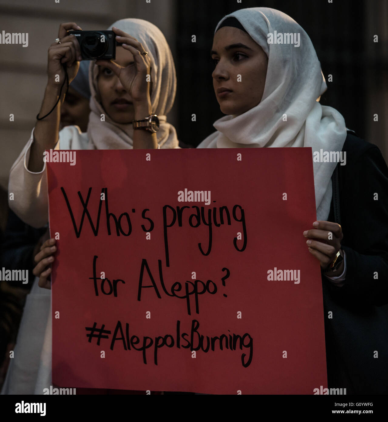 Barcelona, Catalonia, Spain. 6th May, 2016. Two young women with their placard take part in a concentration in front of Barcelona's town hall in solidarity with Aleppo as part of the 'Worldwide Red Protest - Aleppo Is Burning' protest Credit:  Matthias Oesterle/ZUMA Wire/Alamy Live News Stock Photo