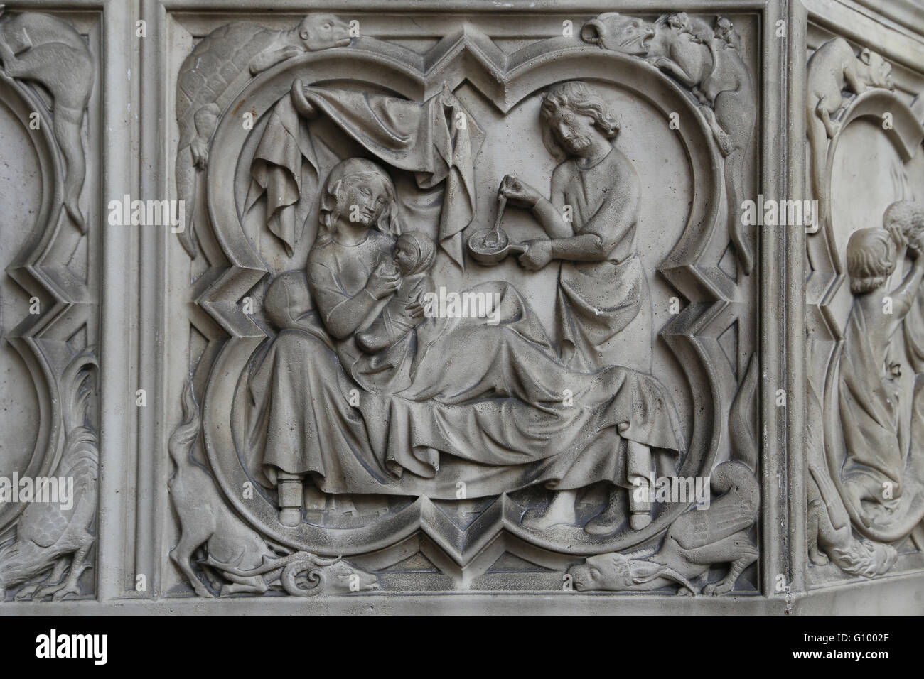 Adam preparing food for Eve who is in bed nursing a child. Relief. 13th c.  Sainte-Chapelle, Paris,France. Stock Photo