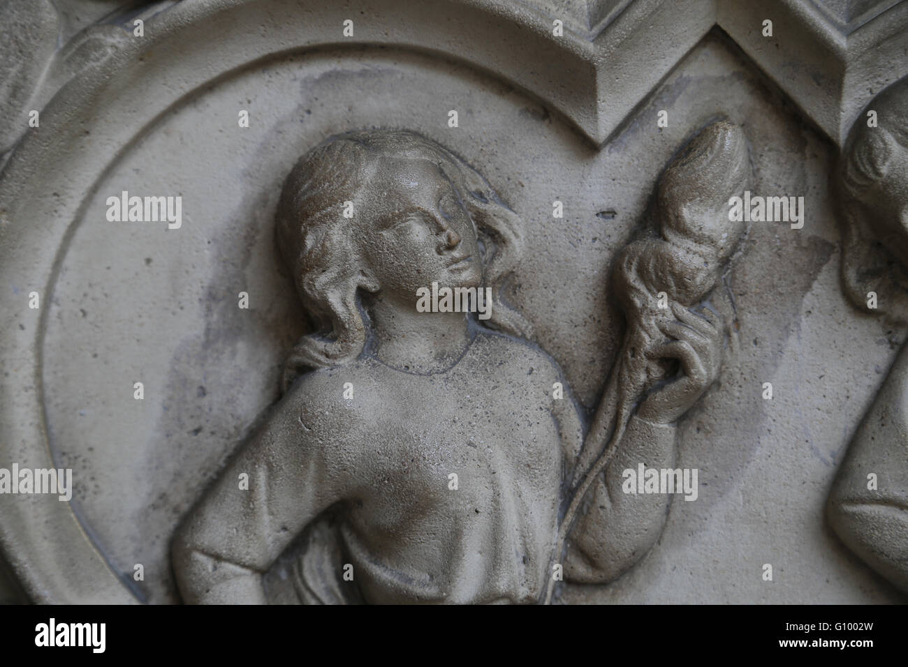 Relief. Genesis. Eve spinning. 13th c. Base of the portal of the Upper Chapel. La Sainte-Chapelle, Paris, France. Stock Photo