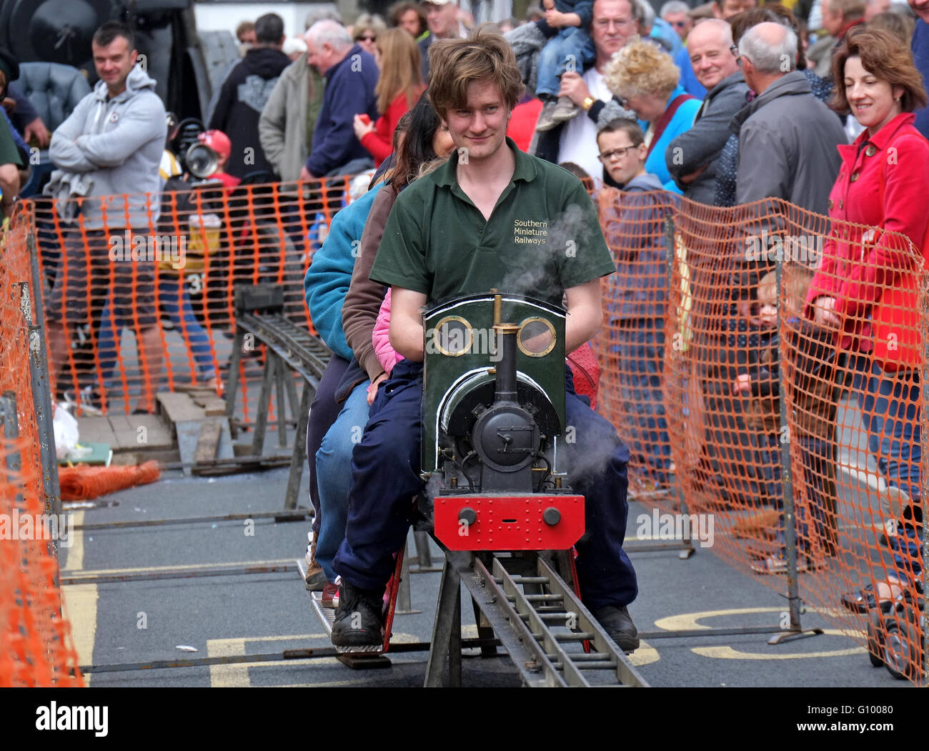 A young man driving a Model steam engine at a fair in Cornwall, UK Stock Photo
