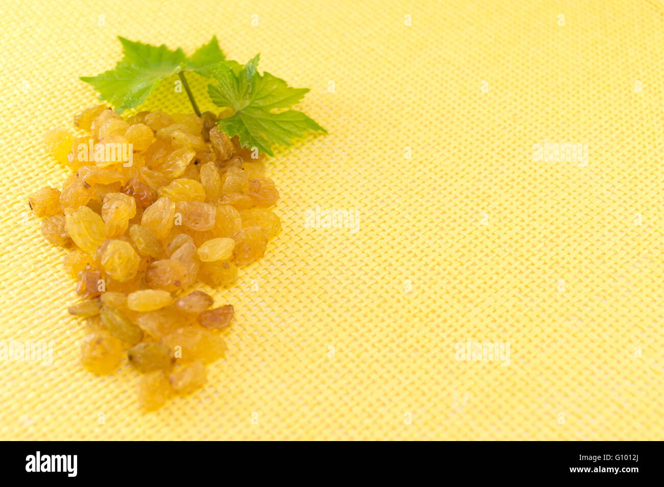 Raisins forming a grape cluster on yellow background Stock Photo