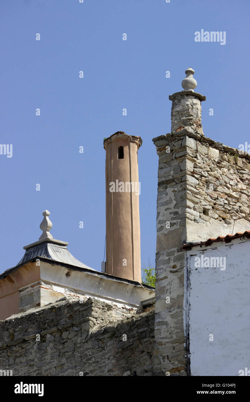 Stone chimneys of IMARET historical Ottoman period monument and Kavala's old city castle stone walls enceinte border (right) Stock Photo