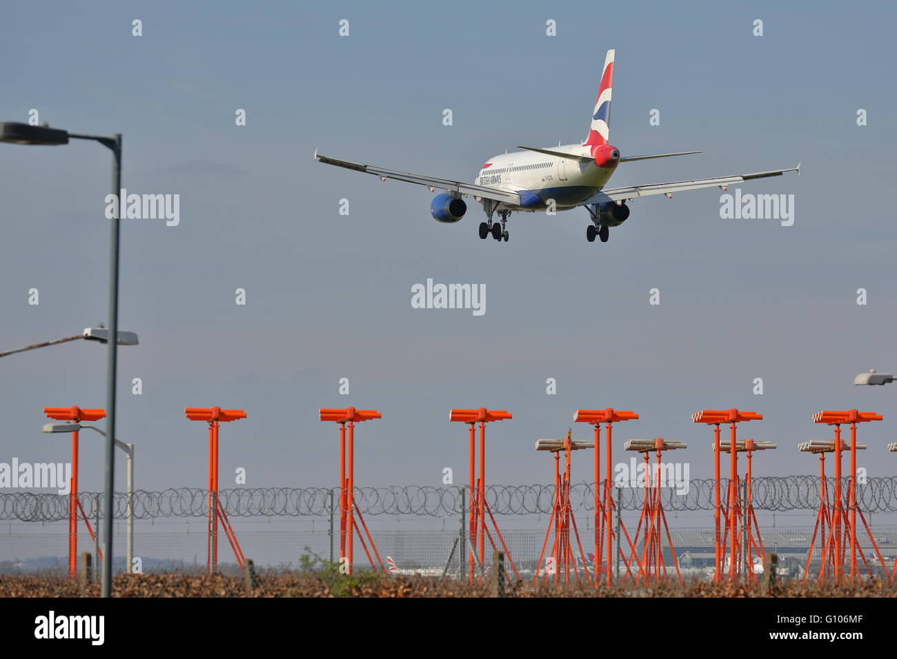 British Airways Airbus A320-200 G-EUYG in its final approach at London Heathrow Airport, UK, flying over the landing lights Stock Photo