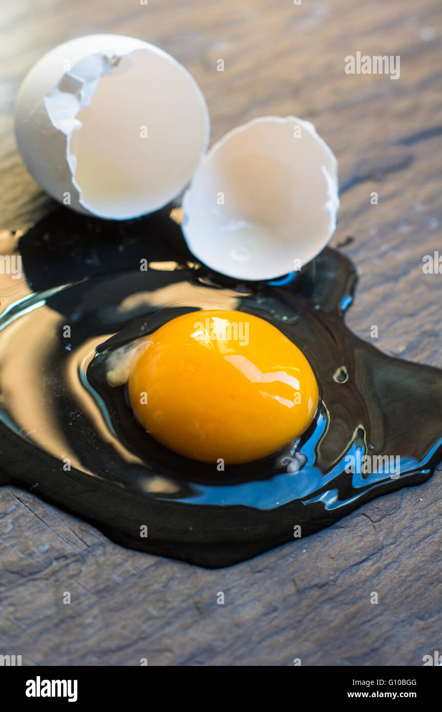 Raw broken egg on dark background Stock Photo - Alamy