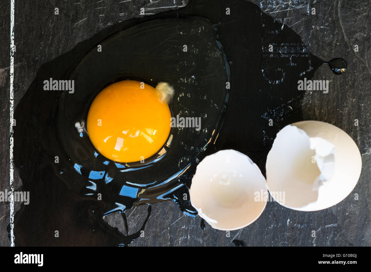 Raw broken egg on dark background Stock Photo - Alamy