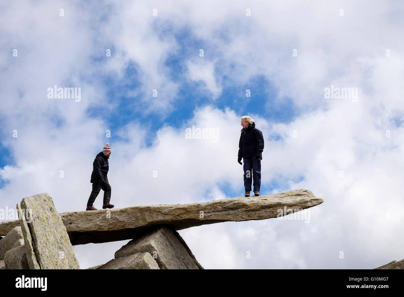 Two female hikers standing on cantilever rock on Glyder Fach in Glyderau mountains of Snowdonia National Park Wales UK Britain Stock Photo