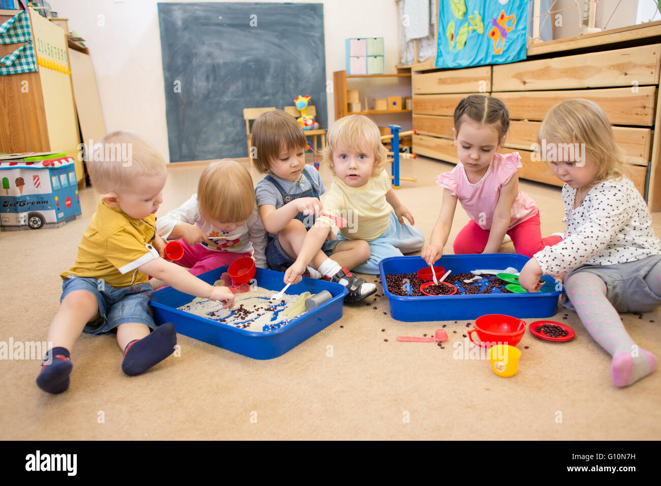 Children improving motor skills of hands with rice and beans Stock Photo