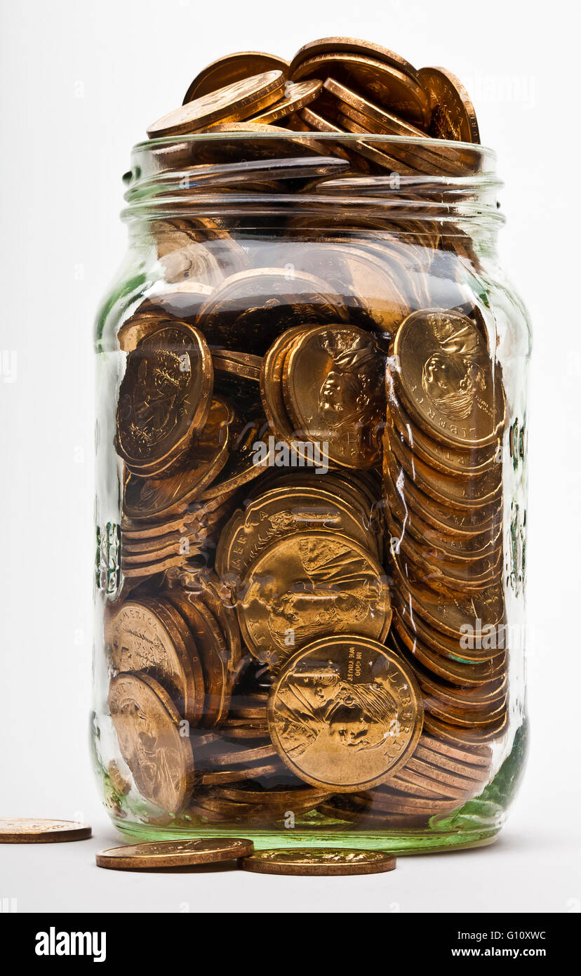 full overflowing jar of US dollar gold coins Stock Photo