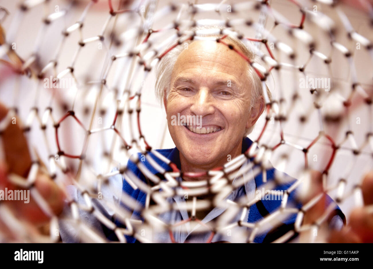 Sussex University, Brighton, England, UK. September 2004. Portrait of Sir Harry Kroto, one of the team of chemists who won the Nobel Prize in 1996 for discovering buckyballs, or Buckfullerine, carbon atoms in the form of a ball. He is holding the model of a buckyball he made.  Sir Harry died on 30 April 2016. Credit:  Roger Bamber/Alamy Live News Stock Photo