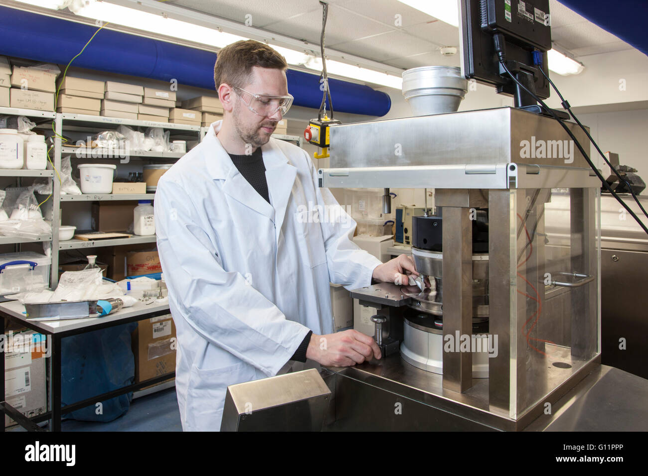 Research at the Institute of Pharmaceutics and Biopharmaceutics. Doctoral student at the tablet press machine. Stock Photo
