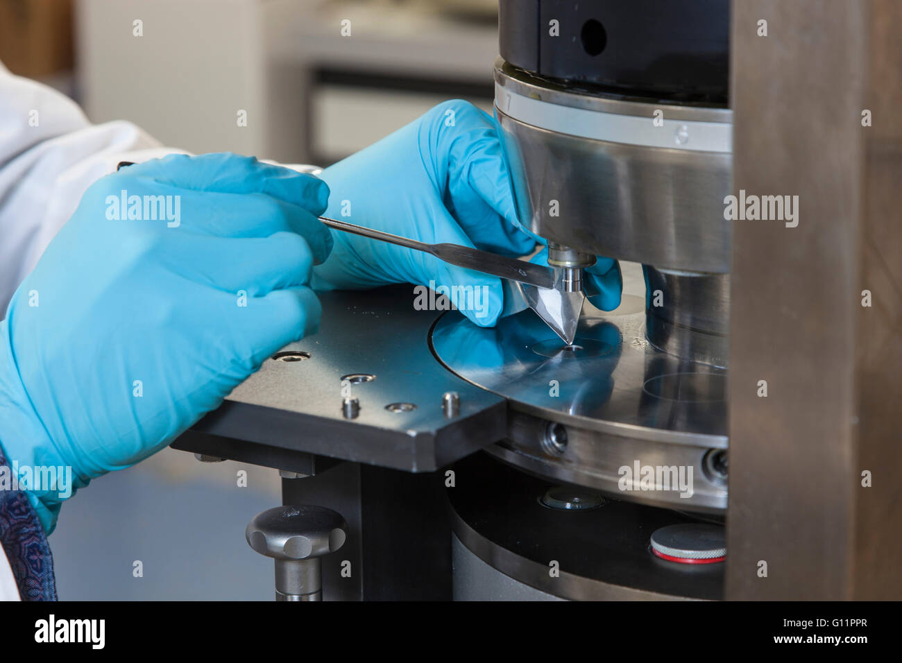 Research at the Institute of Pharmaceutics and Biopharmaceutics. Doctoral student at the tablet press machine. Stock Photo
