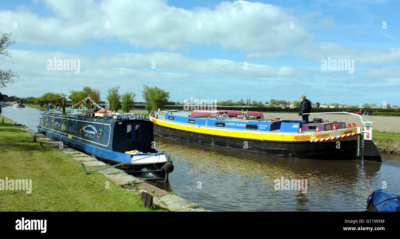 A old working canal boat passes a modern working boat on The Leeds and Liverpool canal in West Lancashire. Stock Photo