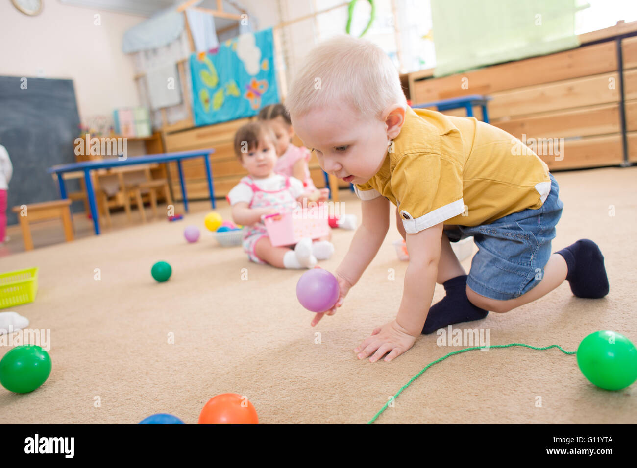 kid playing with balls in kindergarten Stock Photo