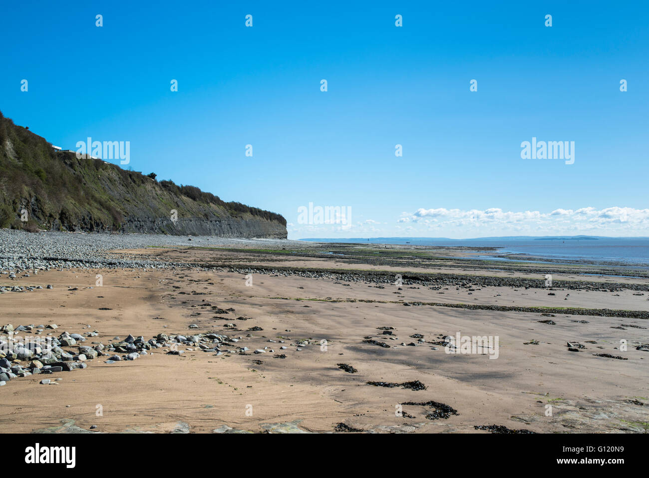 A sand and pebble beach below a headland. Stock Photo