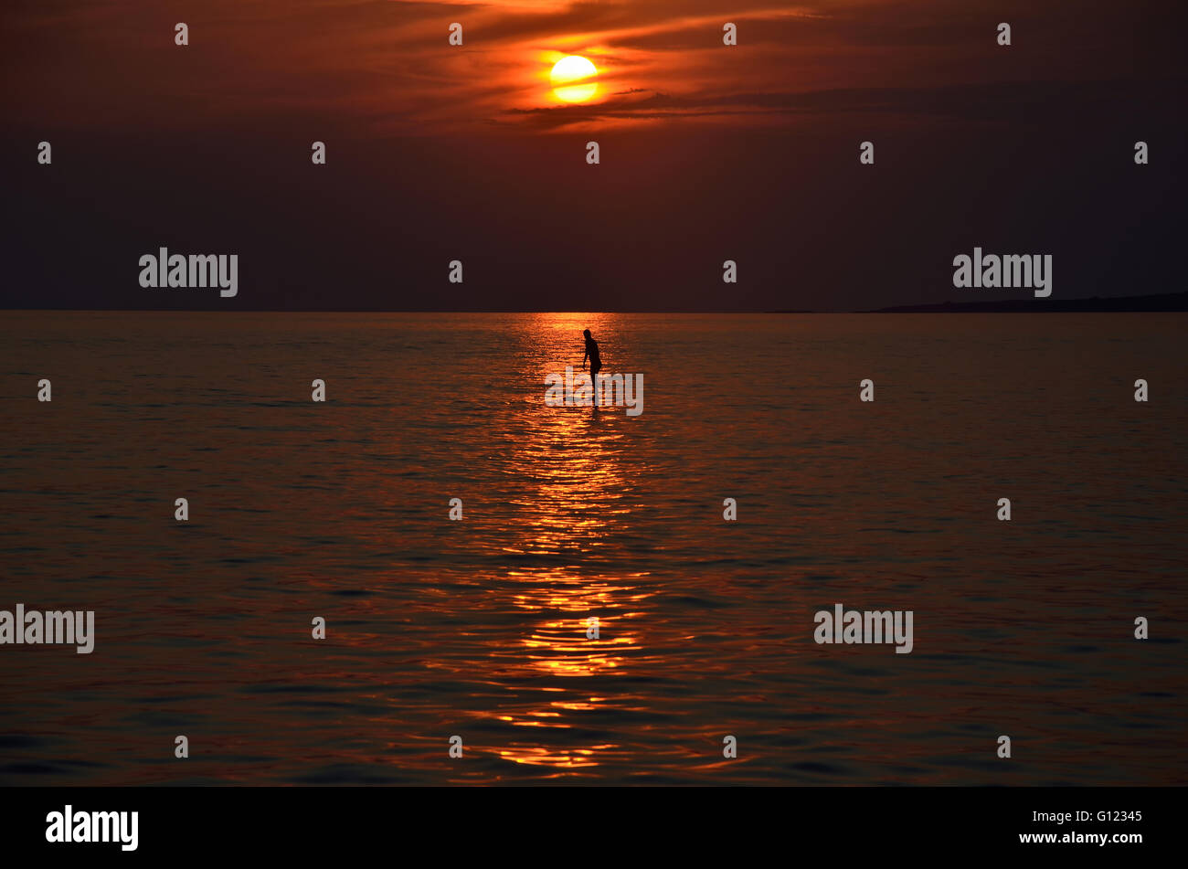 Sunset on sea with women silhouette and sun reflection on the water ...
