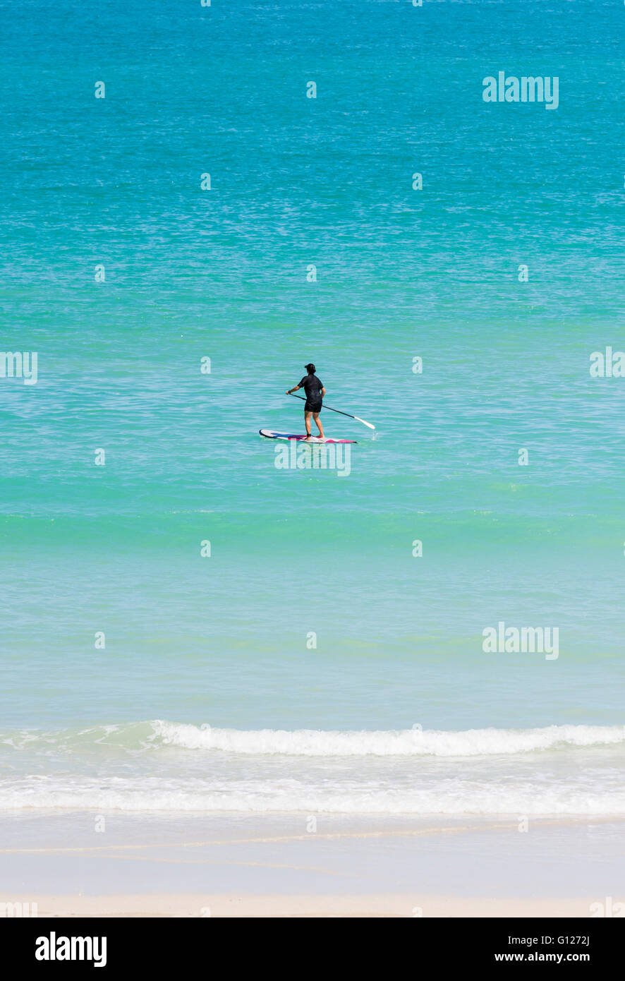 A woman Stand Up Paddling off Cable Beach, Broome, Kimberley, Western Australia Stock Photo
