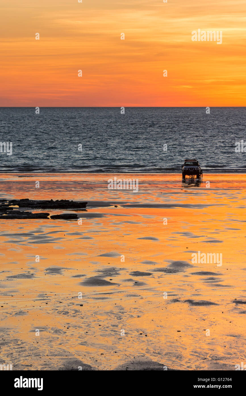A four wheel drive parked on the beach at sunset, Cable Beach, Broome, Kimberley, Western Australia Stock Photo