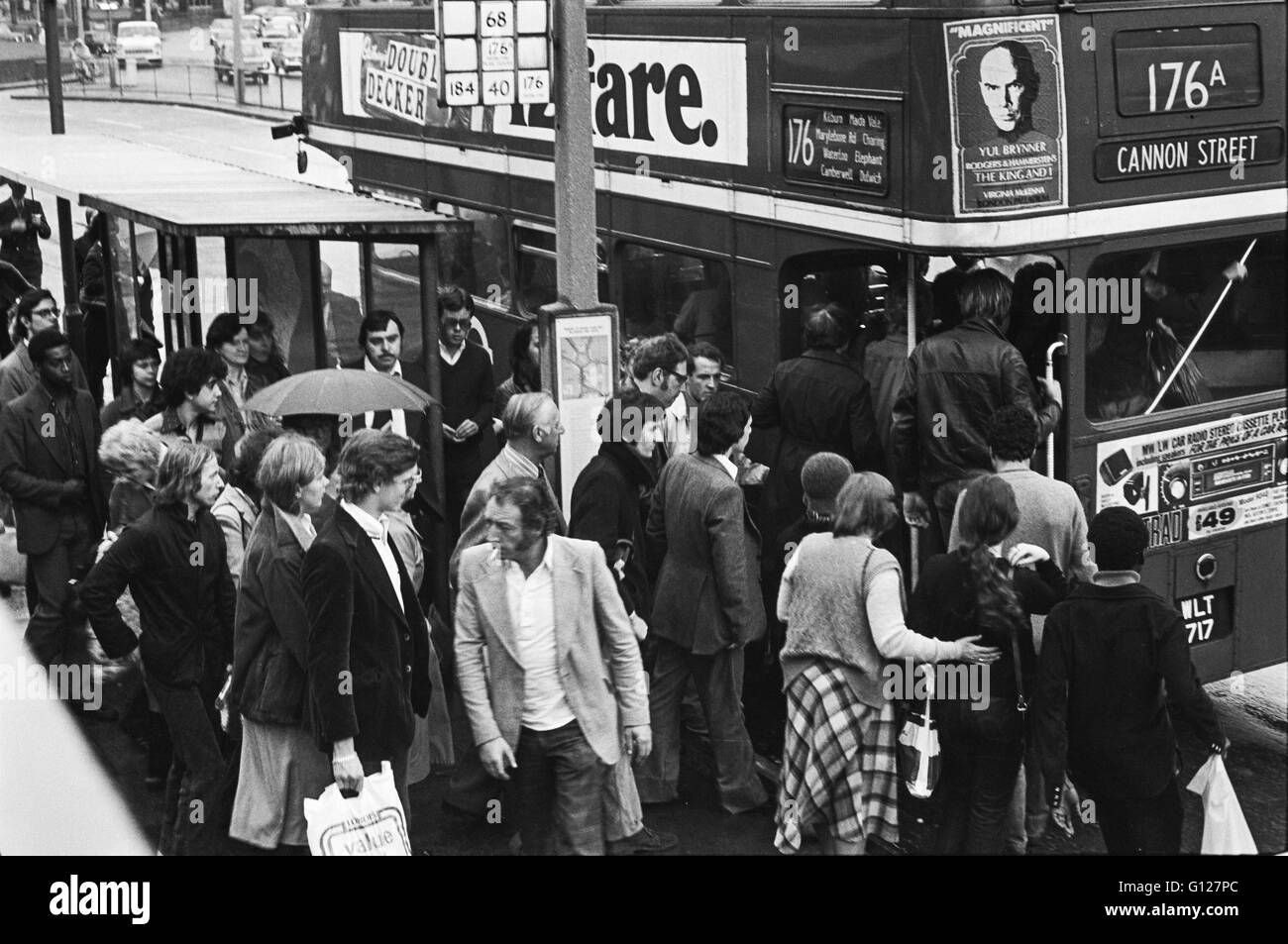 Archive image of a bus queue and no 176 bus arriving at a bus stop on a rainy day in Lambeth, London, England 1979 Stock Photo