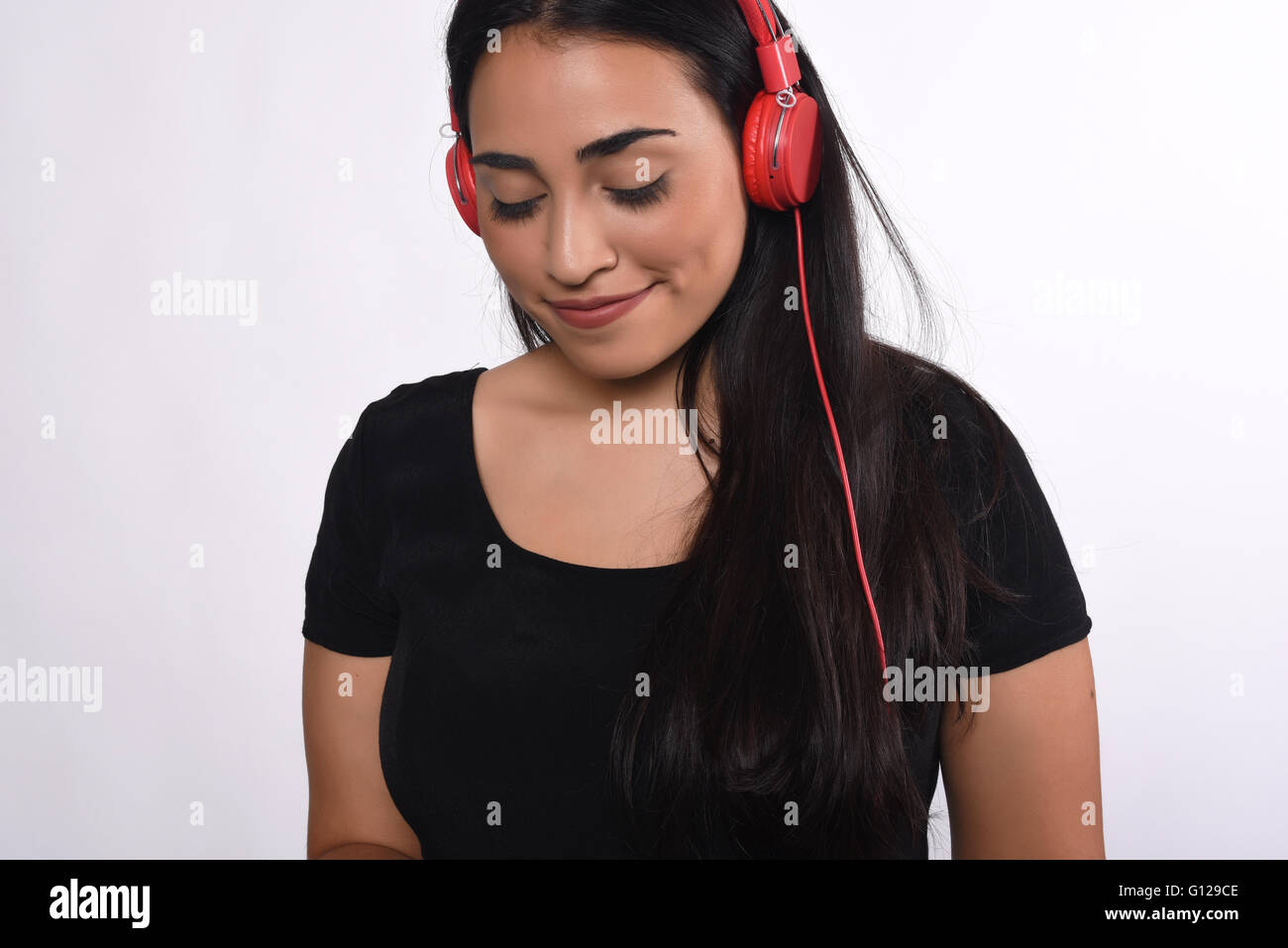 Portrait of young beautiful woman listening to music indoor. Isolated ...