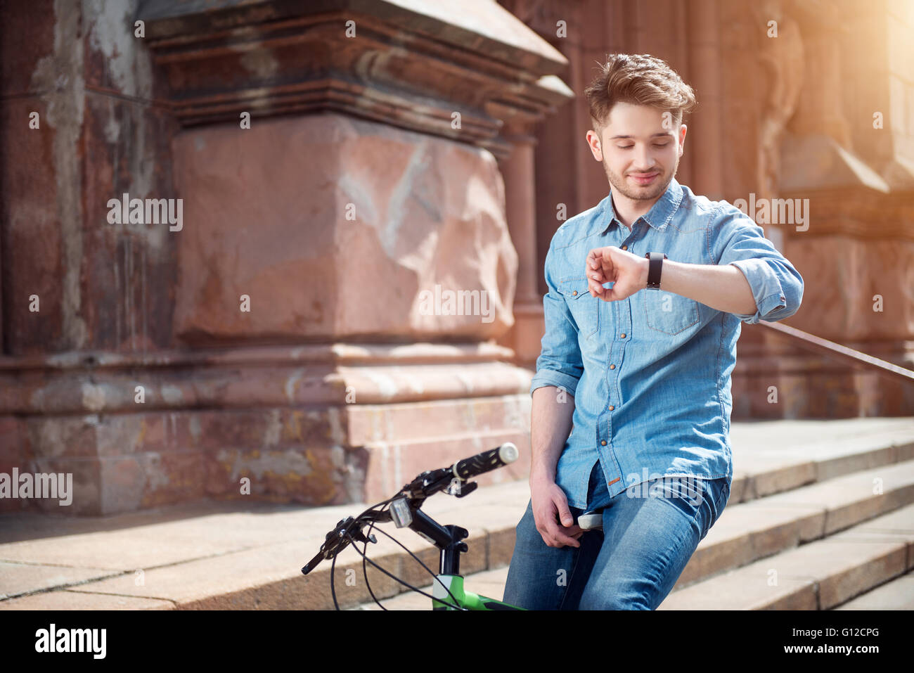 Positive guy sitting on the bicycle Stock Photo