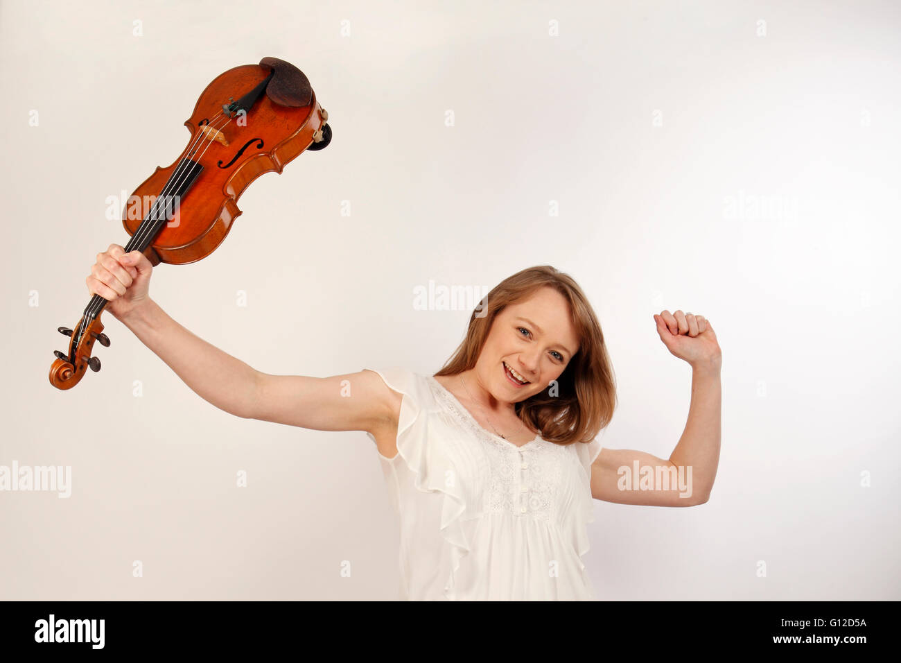 young woman cheering and holding a violin Stock Photo