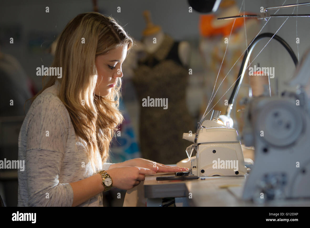 Fashion design students working on mannequins and sewing Stock Photo
