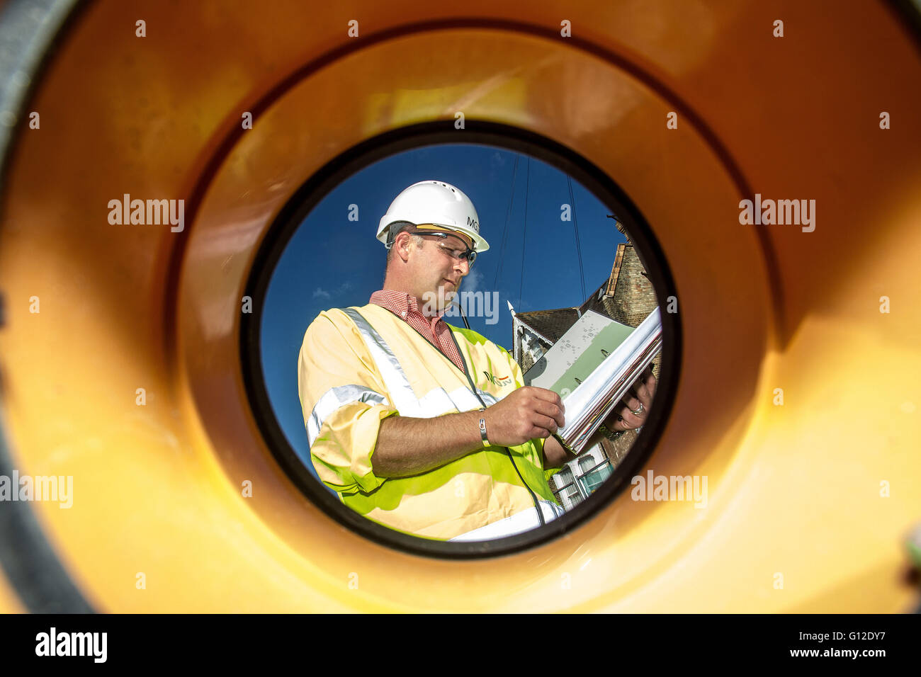 Engineer on site seen through pipe Stock Photo