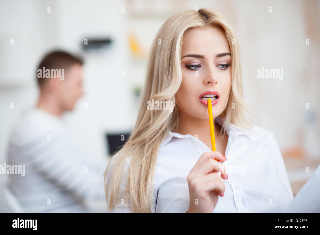 Seductive woman holding pencil in her mouth Stock Photo - Alamy
