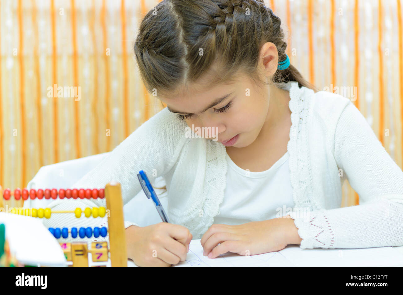 A schoolgirl writing at her desk Stock Photo - Alamy