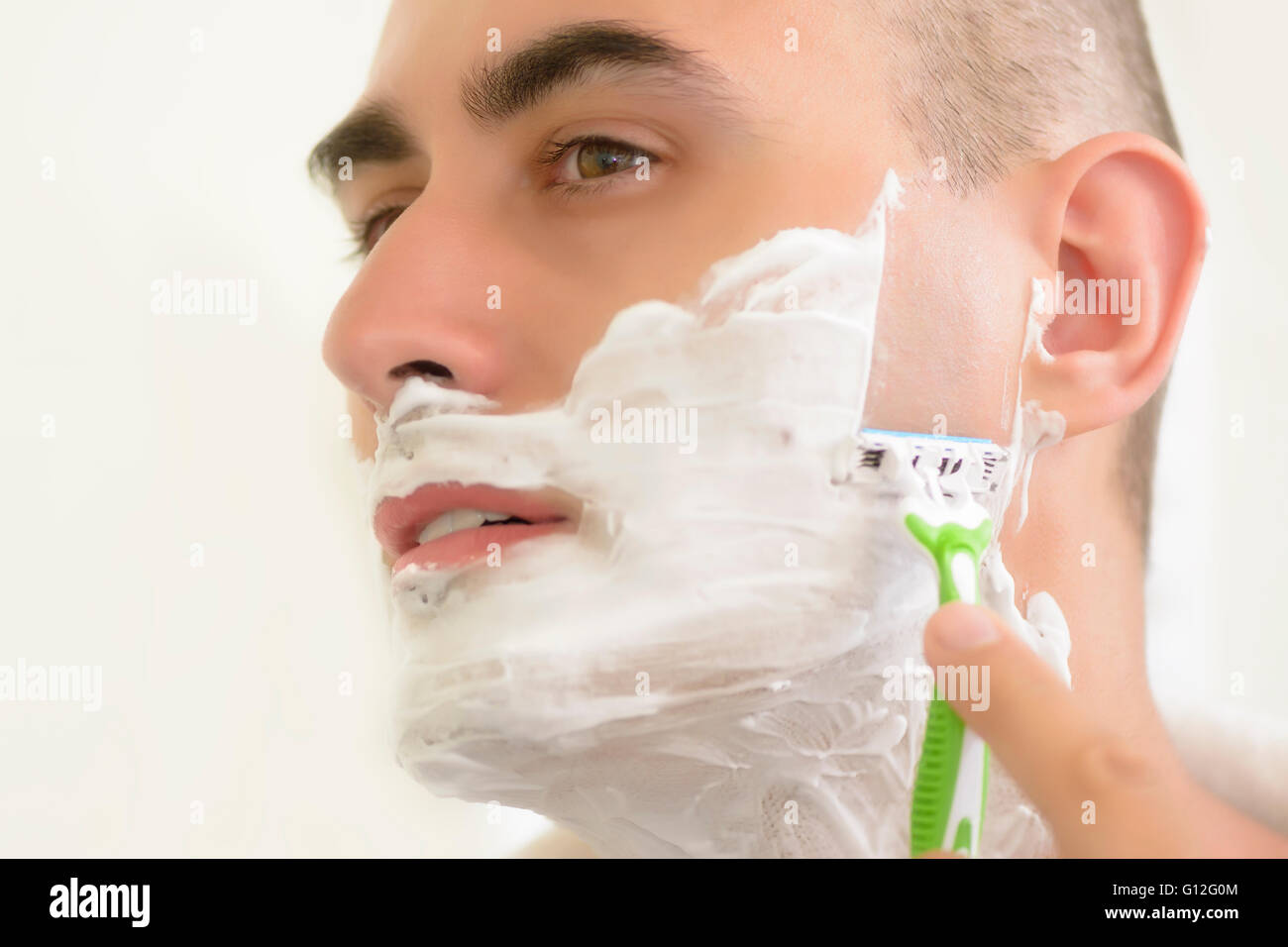 Young man shaving using shaving blade Stock Photo Alamy