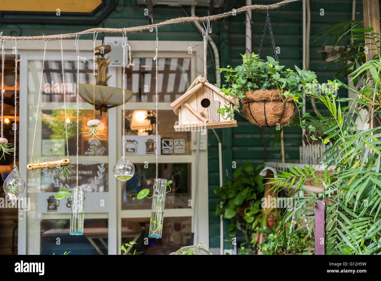 cafe with birdhouse nestles,glass bottle,flower Stock Photo