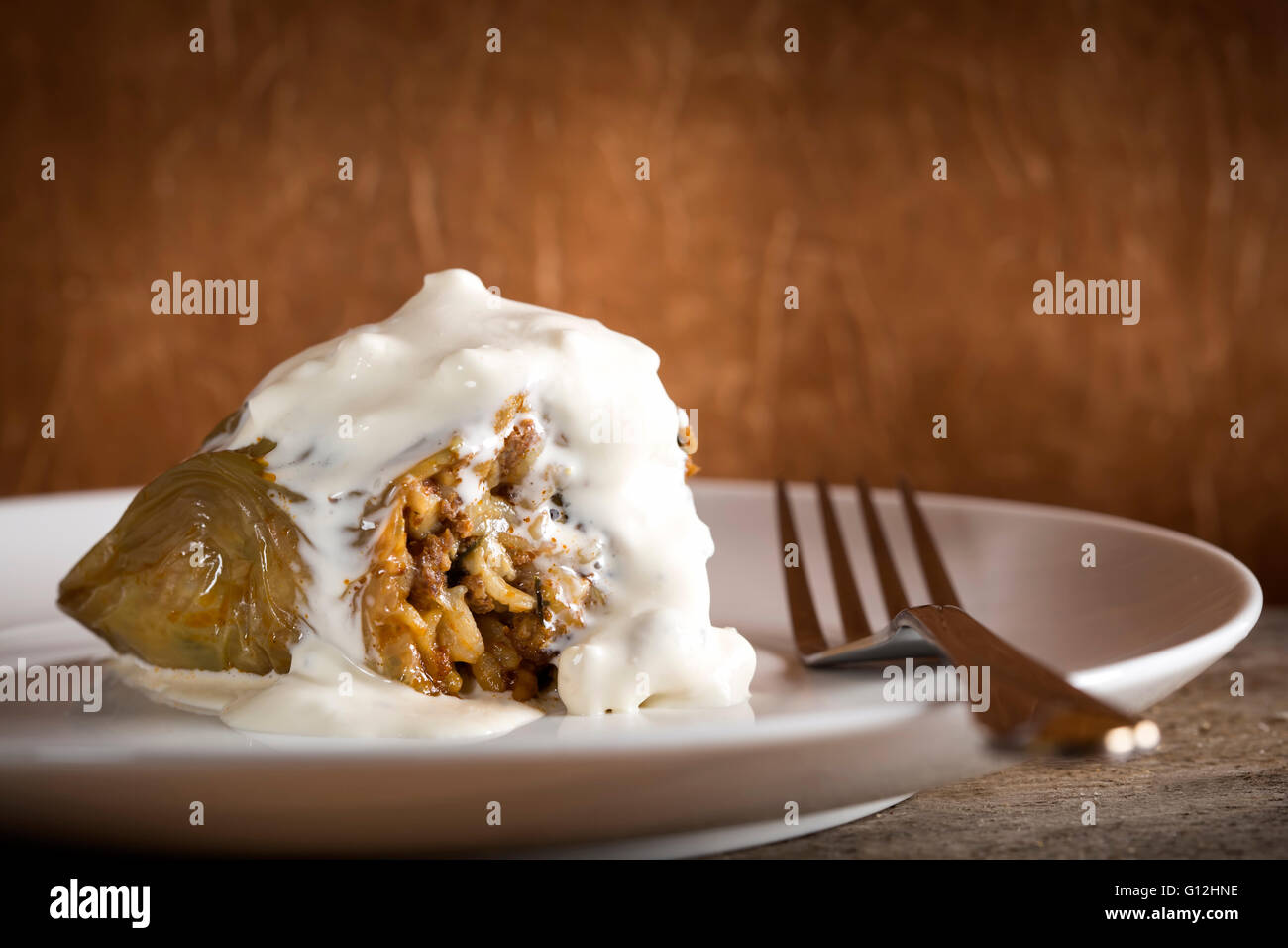 Pepper stuffed with meat and sour cream on white plate Stock Photo