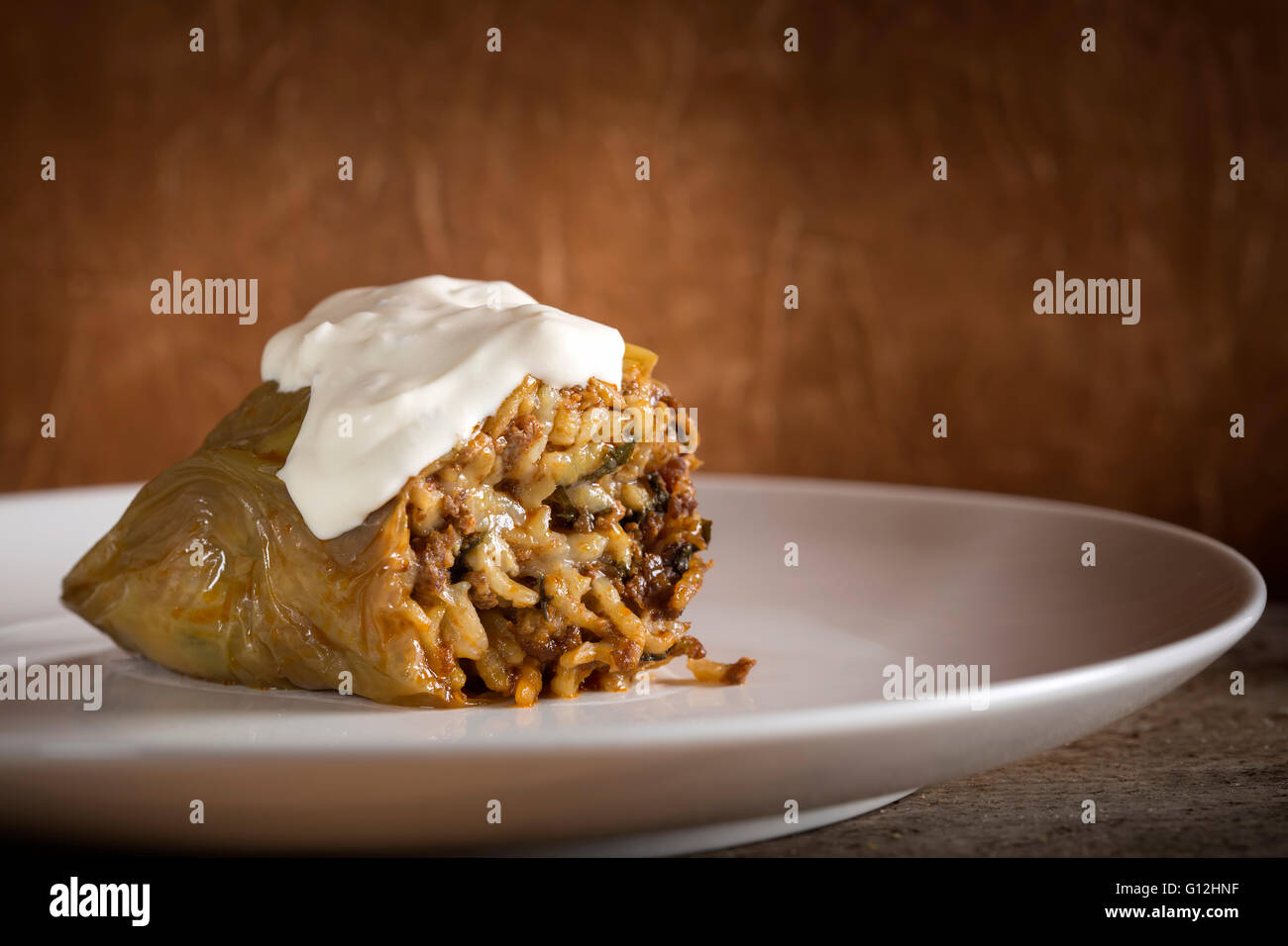 Pepper stuffed with meat and sour cream on white plate Stock Photo