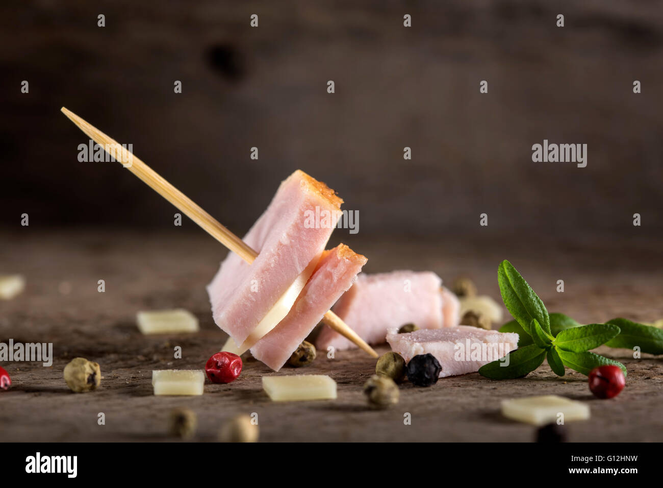 Mini ham and cheese appetizer with spices over wooden background Stock Photo