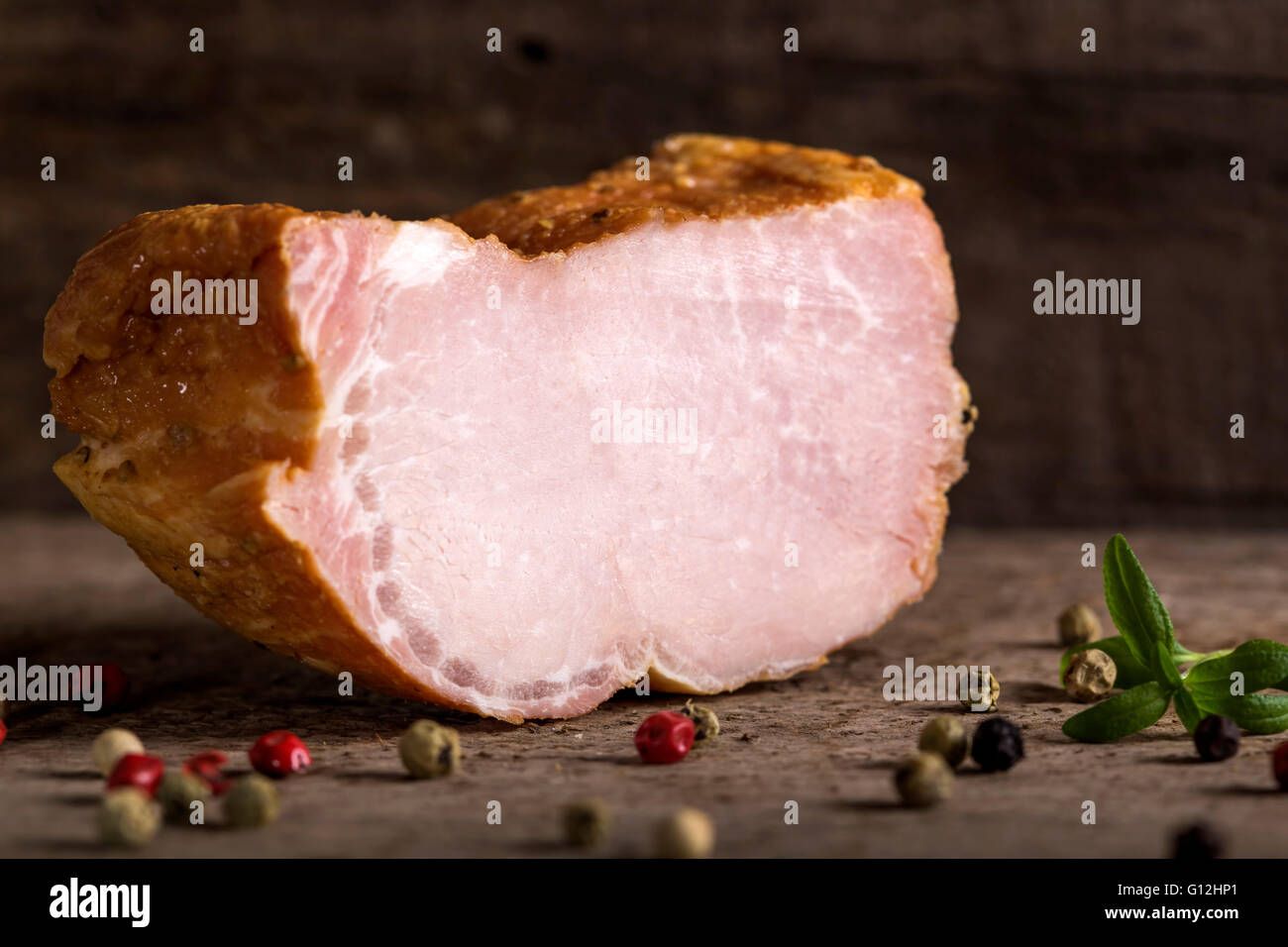 Smoked pork loin with spices over wooden background Stock Photo
