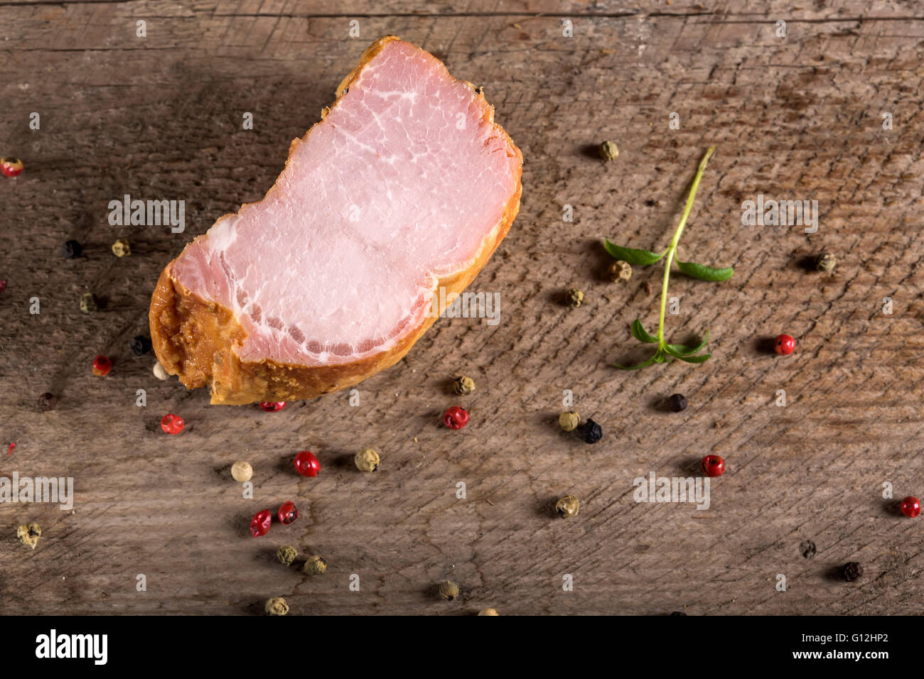 Smoked pork loin with spices over wooden background Stock Photo