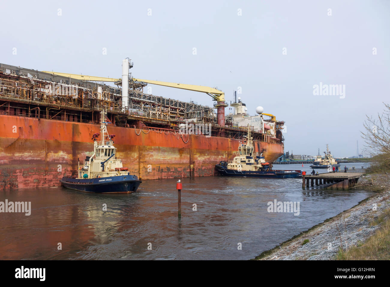 Harbour tugs preparing the Producer offshore oil production system ship for movement to a new location Stock Photo