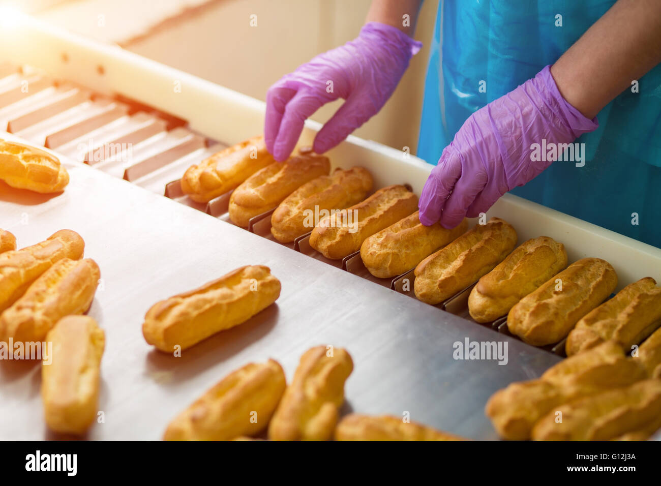 Hands in gloves touching eclairs Stock Photo Alamy
