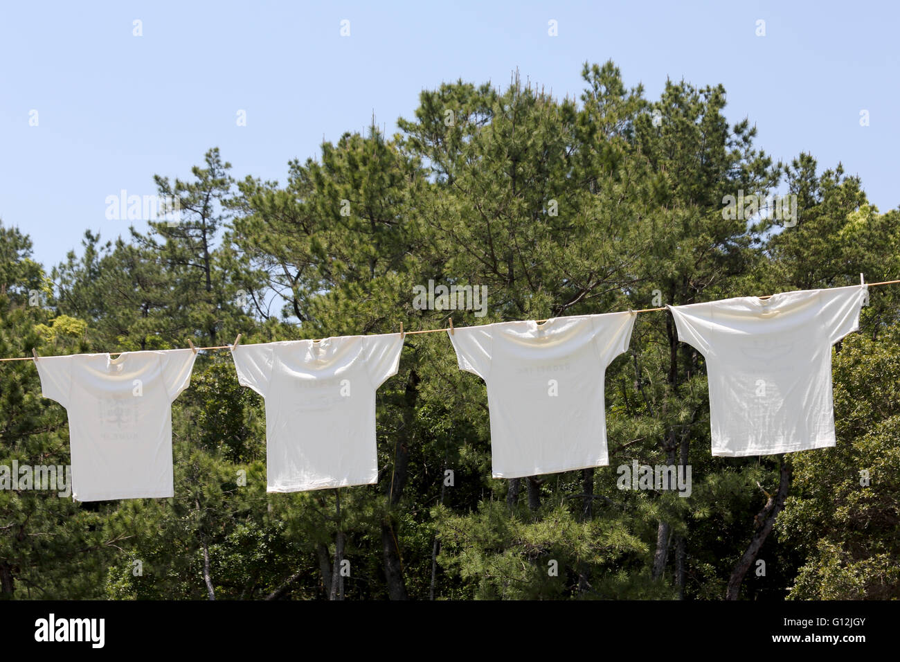 White laundry hanging on the clothesline against blue sky Stock Photo