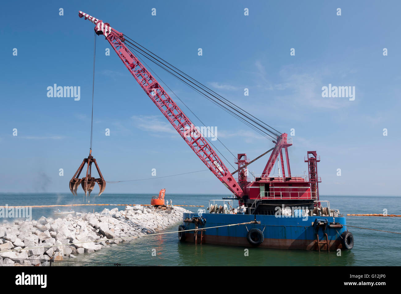 Industrial floating sea crane for carrying the rocks and stones Stock Photo
